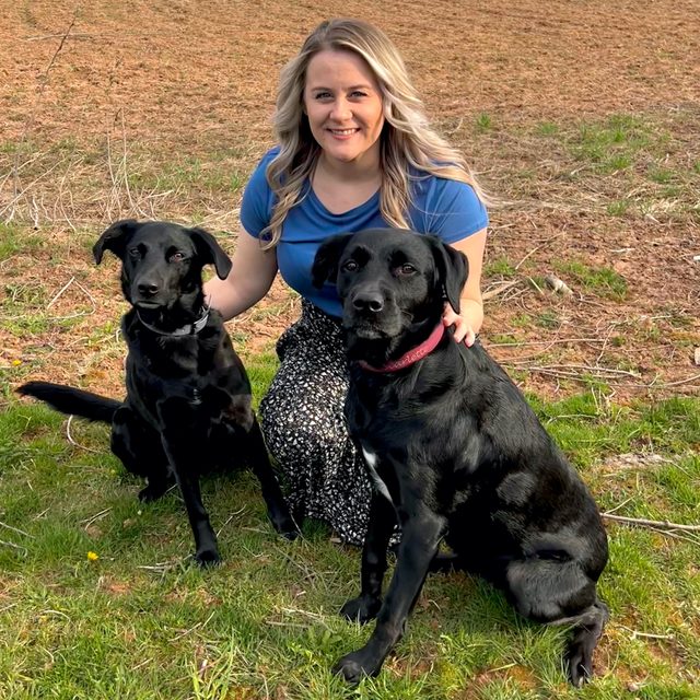 Dr. Jasmine McKenna with her two black lab mixes
